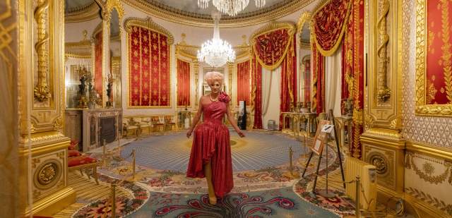 A person in glamorous dress walks through interior of Brighton Royal Pavilion