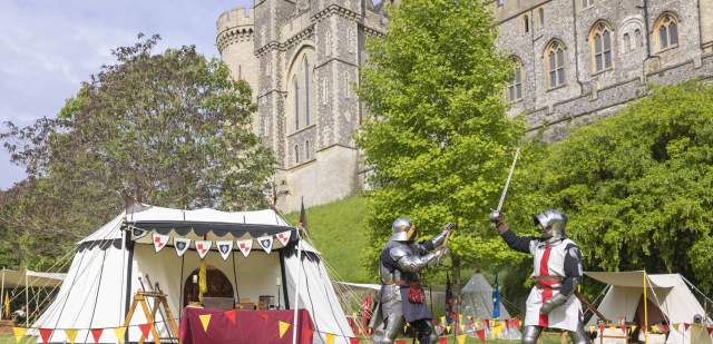 Two knights in medieval costume and armour in the grounds of Arundel Castle, Sussex
