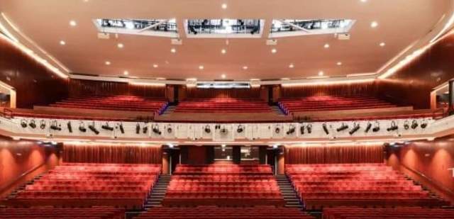 The Eastbourne Theatre Auditorium as seen from the stage, the seats are red, with a balcony