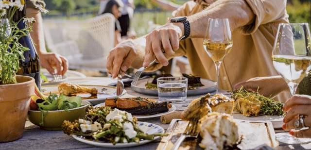 A group of people sharing plates of food at Artelium vineyard