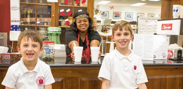 Two younger boys at a soda shop getting Cheerwine floats