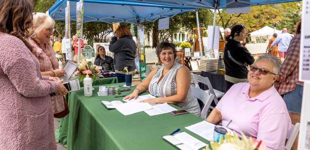 Group working and group visiting information tent at an event