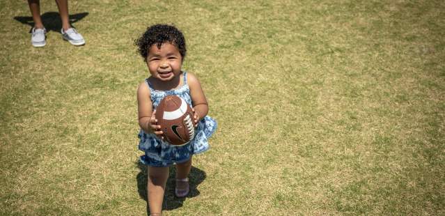 Little girl holding football