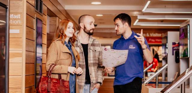 Staff helping a couple in the Visit Belfast Welcome Centre.