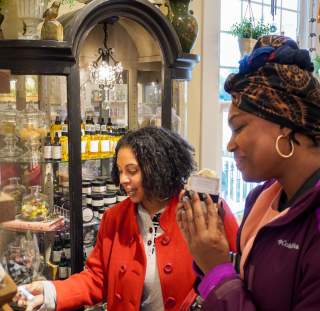 Two visitors happily browsing and discovering local products in a charming Fayetteville, NC boutique.