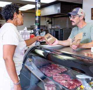 A woman purchases fresh meat from Noble Meats butcher shop near Spring Lake, NC.