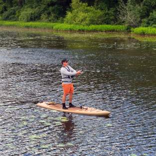 Man on paddleboard fishing in Huron River