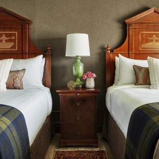 Two beds with U-M pillows at Graduate Ann Arbor
