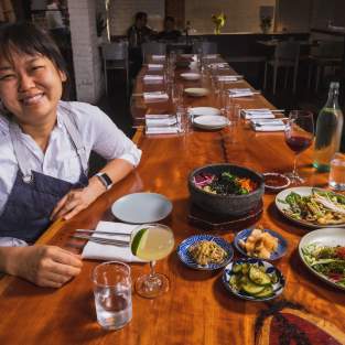 Chef Ji Hye Kim at a table of Korean food