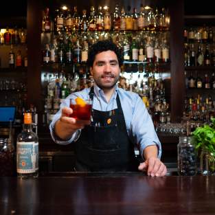 Bartender holding up a drink at The Last Word