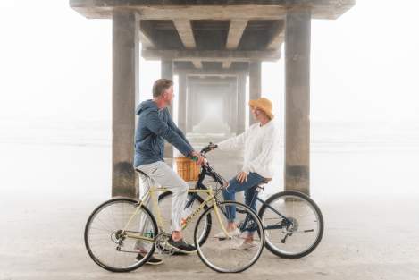 Couple on bikes under a pier