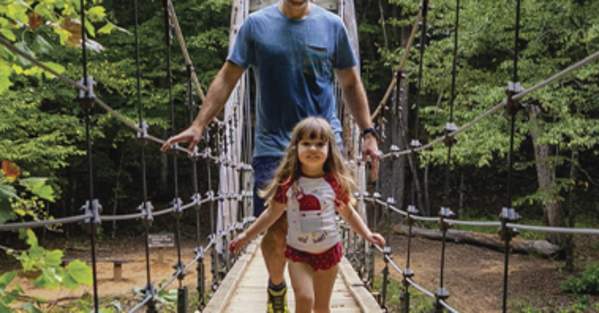 People Crossing a Plank Bridge at Eno River State Park