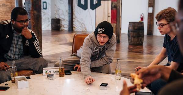 Three people drinking beer and playing a game