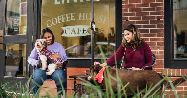 two women with their dogs and coffee