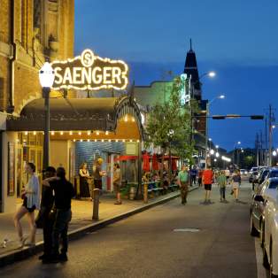 night time street view of the Saenger theatre with lighted, covered entrance