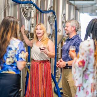A woman guides a group through a brewery