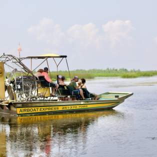 Yellow airboat with passengers in still waters