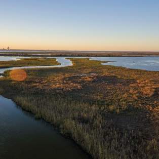 water and grass land masses at sunset
