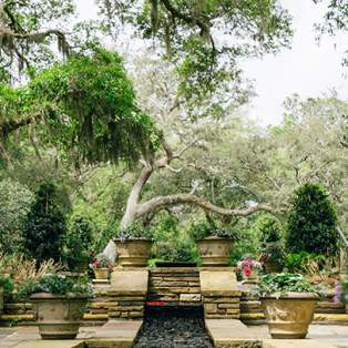 Multi-layered stone slab fountain in the middle of a wooded area