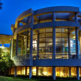 Exterior of Mobile Museum of Art. Large, round building with walls made of glass.