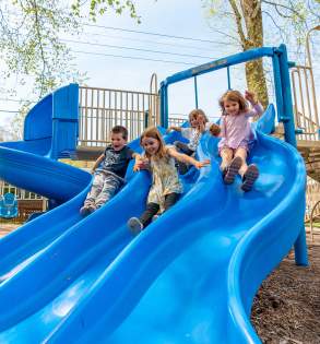 Laurelville Summer Camp Children sliding down a blue slide