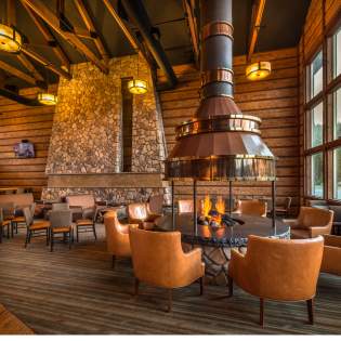 Tables gathered around an indoor firepit in the Brian Head Lodge.