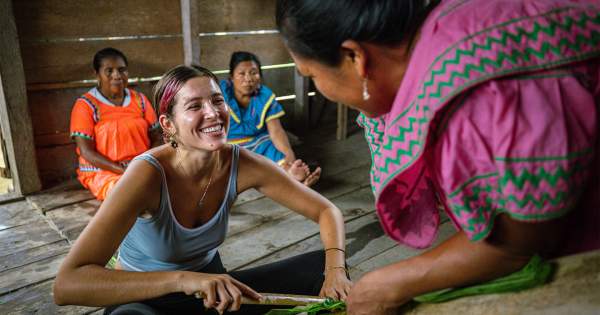 Tourist learning handcraft with Messijablado woman