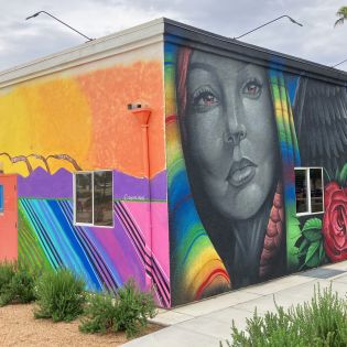 Three different colorful murals are painted on the sides of two walls at Coachella City Hall.