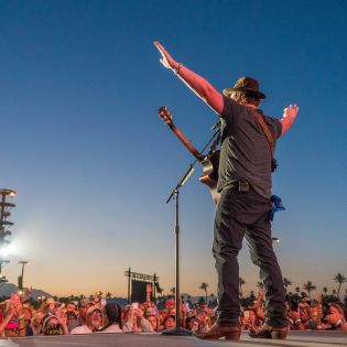Country music star singing to large crowd at Stagecoach Music Festival.