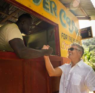 Image of a tourist giving a handshake to a local