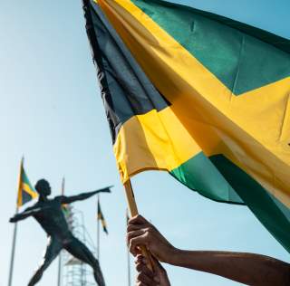 Jamaica Flag Celebration at National Stadium Bolt Statue
