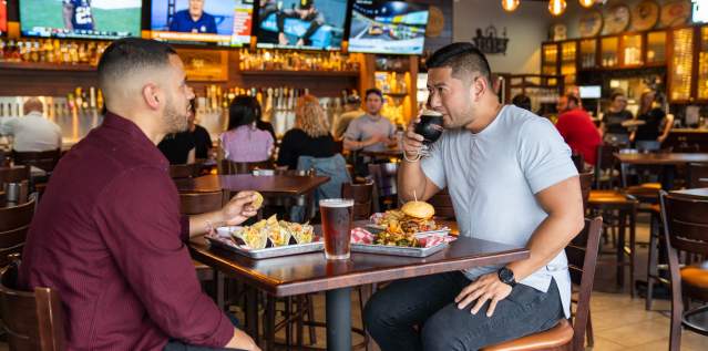 two men enjoying beer and food at 859 taproom