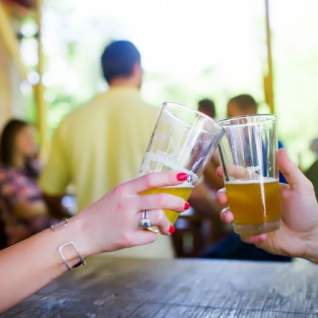 Hands holding pint glasses of beer