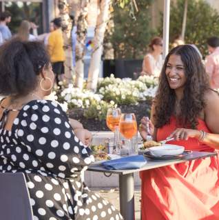 Two Black women having dinner at Alcove restaurant al fresco