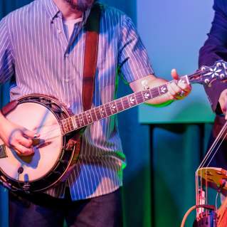 A musician plays the banjo at a music venue.