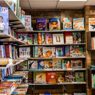 Two walls with floor to ceiling bookshelves filled with children's books at the Frugal Bookstore