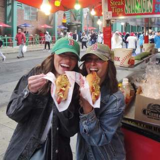 Two people eating Fenway Franks at a Red Sox Game