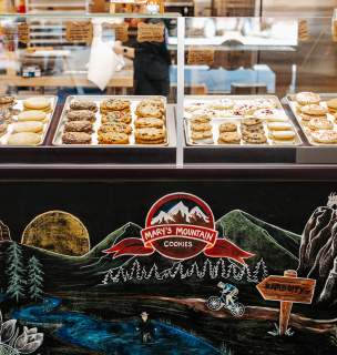 Cookie display at local cookie shop with chalkboard art in front.