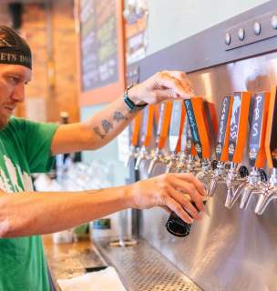 Bartender pouring a beer from the Dakota Point Brewing taps in Rapid City, South Dakota