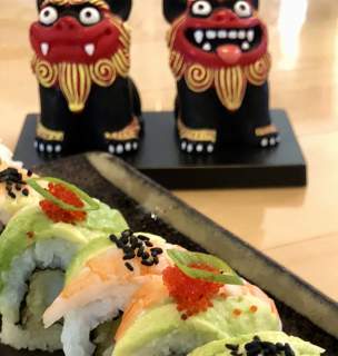 Close up of sushi rolls with Japanese dragons in the background