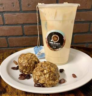 Coffee and energy bites on a plate with a brick background.