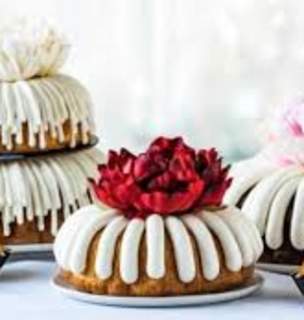 Three bundt cakes with decorative toppers and cream cheese frosting.