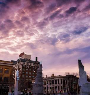 Purple sunset over downtown with fluffy clouds