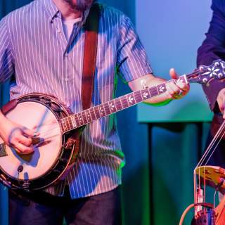 A musician plays the banjo at a music venue.