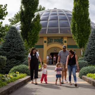 A family with children walking in front of the Reptile Gardens Sky Dome