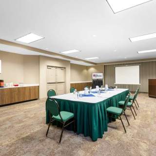 A meeting table sits ready with a presentation easel on the side, and refreshments on the side counters