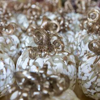 Image shows close up of tan, beige and white colored glass-blown pumpkin
