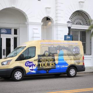 colorful passenger van parked in front of white building