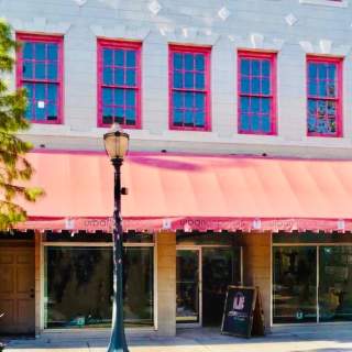 Exterior of Urban Emporium: two story building with an awning across the entire first floor