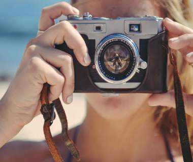 a woman with a camera on the beach